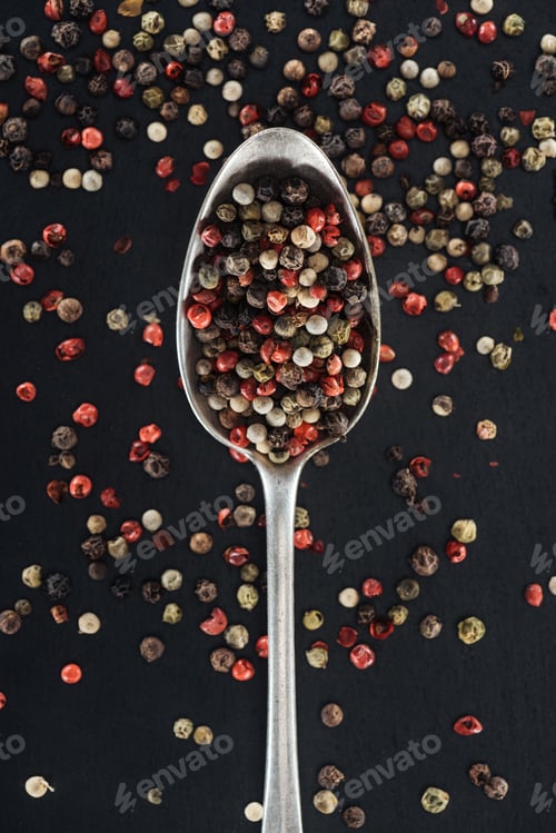 Preview: top view of mix pepper spice in silver spoon on black background