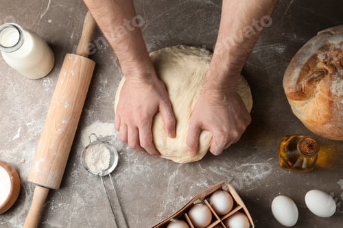 Preview: Male baker preparing bread dough at kitchen table, top view