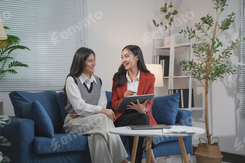 Preview: Financial advisor showing project details on tablet to client in office meeting