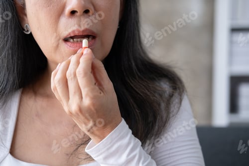 Preview: Close up view of elderly woman taking a pill according to the doctor order.