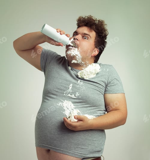 Preview: Shot of an overweight man filling his mouth with whipped cream