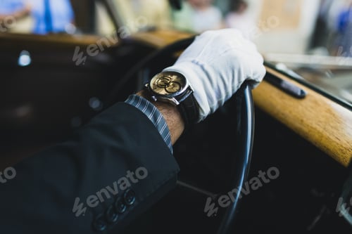 Preview: Detail of the hand of a driver of a luxury classic car.