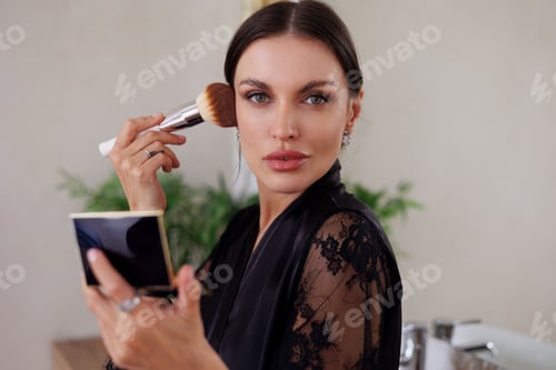 Preview: Young beautiful woman applying make-up in her big apartment. Brunette girl doing self makeup