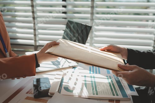 Preview: working atmosphere in an office during the day, an employee is sitting at his desk working with his