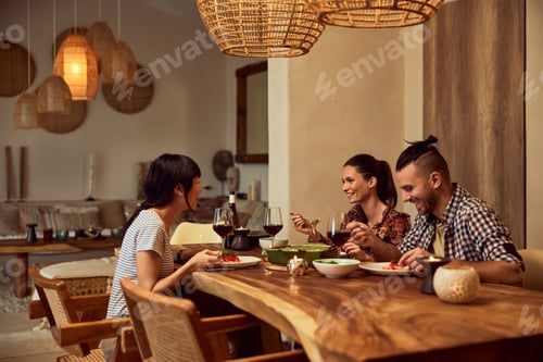 Preview: Group of three friends spending the night together, having dinner, enjoying each other's company.