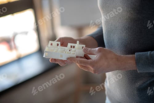 Preview: Interior designer holding little models for apartment