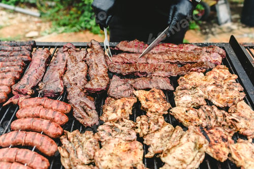 Preview: cook preparing grilled meat during a barbecue.