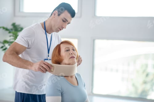 Preview: Professional male doctor putting on cervical collar