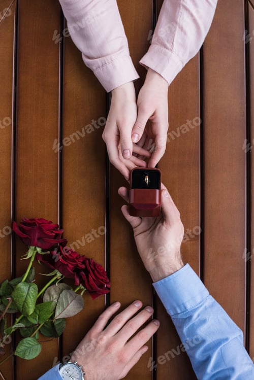 Preview: cropped image of boyfriend proposing girlfriend and holding wedding ring