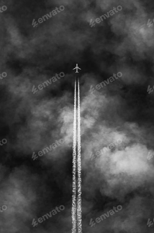 Preview: Vertical grayscale shot of an airplane leaving steam in a cloudy sky