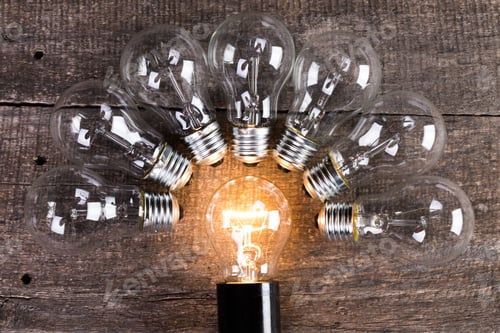 Preview: Electrical light bulb over wooden background close up