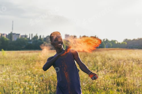 Preview: portrait of happy african american man throwing colorful powder at holi festival
