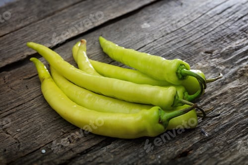 Preview: Stack of green chili peppers, on wooden surface