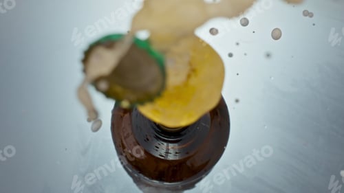Preview: Uncorking bottled craft beer closeup. Unfiltered liquid splashing from flask