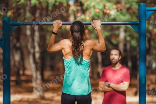 Preview: Woman doing pull-ups in the park