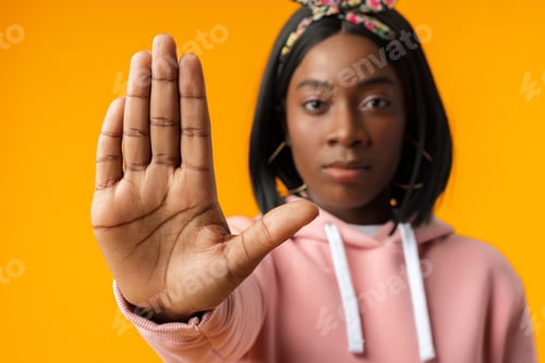 Preview: Young african woman over yellow background doing stop sign with palm of the hand
