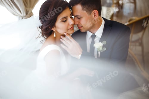 Preview: Young bride and groom in cafe. Husband and wife hold each other's hands. Loving couple in restaurant