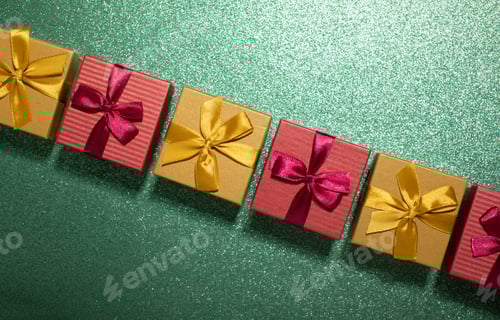 Preview: gold and red christmas gift boxes in row on dark green blinking background