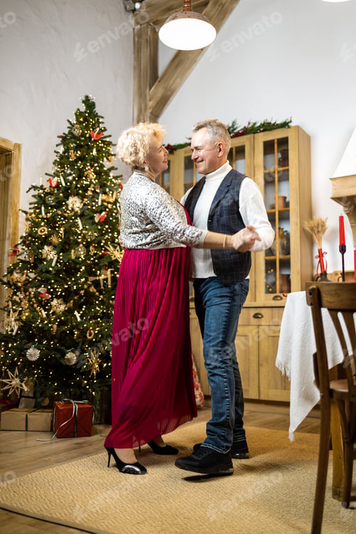 Preview: Mature couple dancing at home in front of the christmas tree