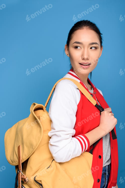 Preview: portrait of beautiful asian student with backpack isolated on blue