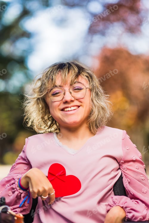 Preview: InspireInclusion heart shape, love valentine gesture. Young woman with cerebral palsy disability.