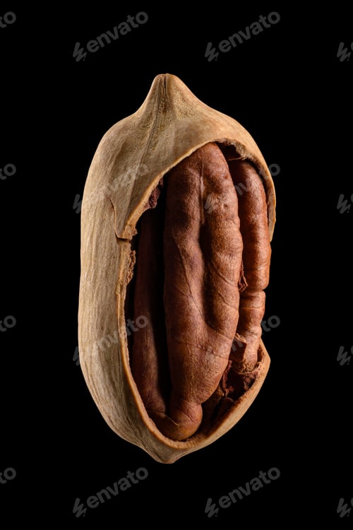 Preview: One half-peeled walnut isolated on black background.