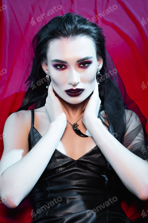 Preview: high angle view of pale and brunette woman looking at camera on red