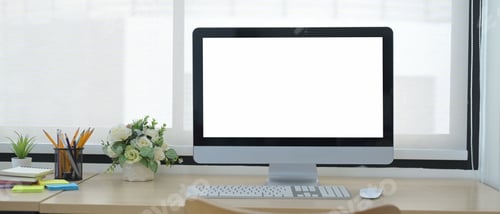 Preview: Front view computer pc with blank screen, flower pot and supplies on wooden table.