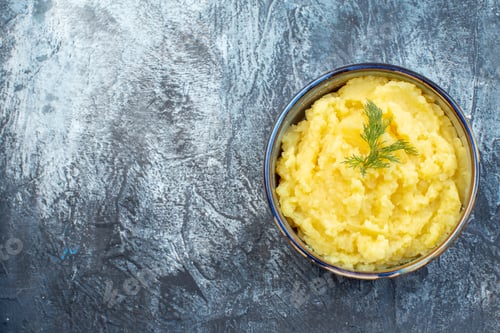 Preview: Top view of mashed potatoes served with dill on tthe left side on dark color background with free