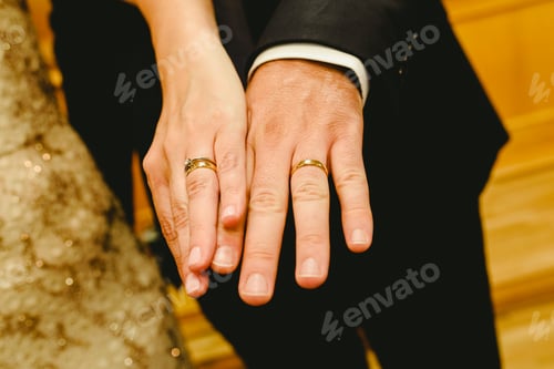 Preview: Newlywed rings shown in the hands of the bride and groom.