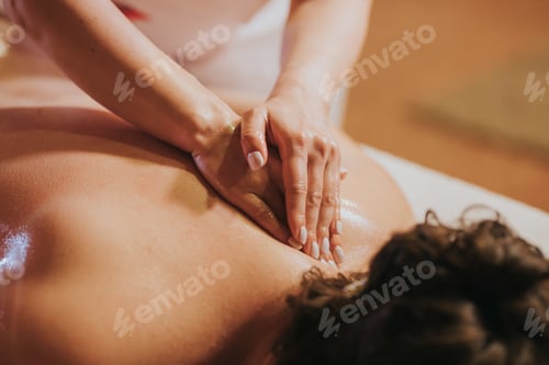 Preview: Woman getting massage treatment against back pain in the spa salon