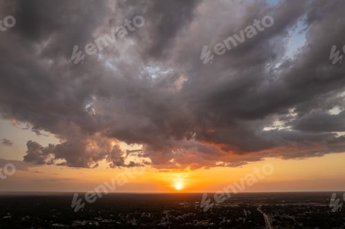 Preview: Bright colorful orange and yellow clouds over dark horizon. Beautiful sunset sky scenery