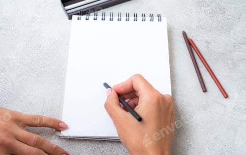 Preview: Girl's hands drawing in notebook