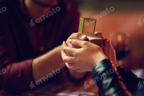 Preview: Cropped shot of a man proposing to his girlfriend with an engagement ring in a box