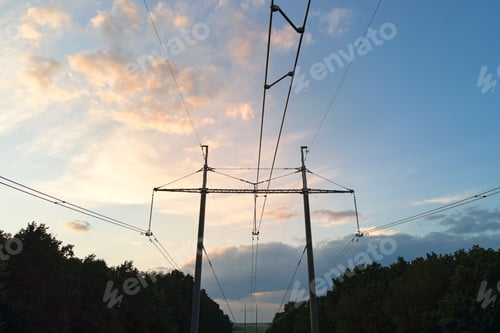 Preview: Dark silhouette of high voltage tower with electric power lines at sunrise.