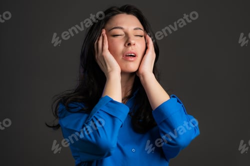 Preview: Bored mature woman with long hair having headache, studio portrait. Girl putting hands on head