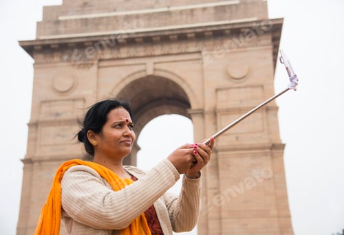 Preview: Tourist taking selfie with smart phone in front of India Gate, Delhi, India.