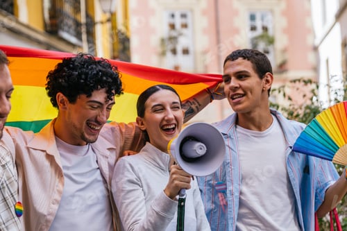 Preview: Joyful people celebrating pride day with rainbow flag