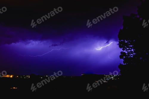 Preview: Rays in a night storm with light and clouds.