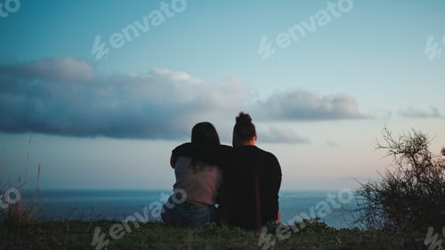 Preview: Engaged couple looks towards the horizon