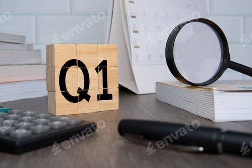 Preview: Close up image of wooden cubes with alphabet Q1 on office desk.