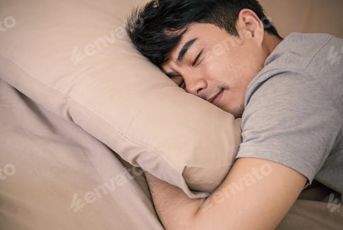 Preview: Young asian man with attractive smile laying on bed