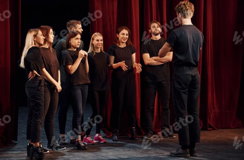 Preview: Group of actors in dark colored clothes on rehearsal in the theater
