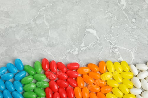 Preview: Flat lay composition with jelly beans on light background. Space for text