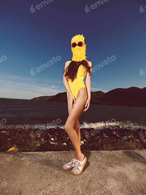 Preview: Woman, yellow swimsuit, sunglasses, concrete wall, water a woman in a yellow swimsuit and sunglasses