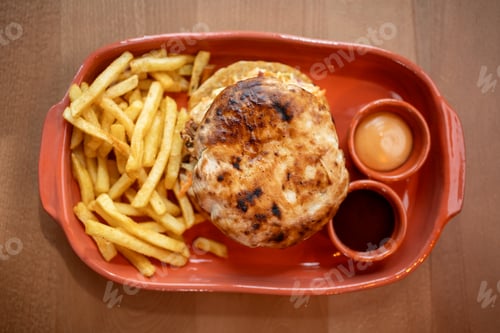 Preview: Mouthwatering burger with crispy fries served on a vibrant platter