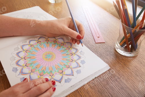 Preview: Woman hands drawing in adult colouring book