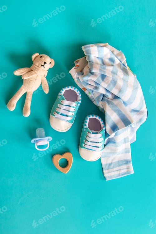 Preview: Baby clothes and accessories on the blue background. Selective focus.