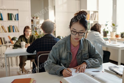Preview: Asian Woman Studying at Desk in School Library