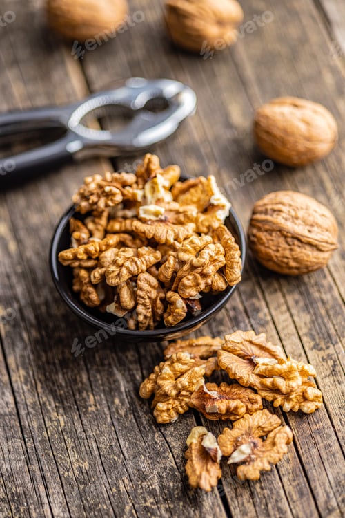 Preview: Peeled dried walnut kernels on wooden table.